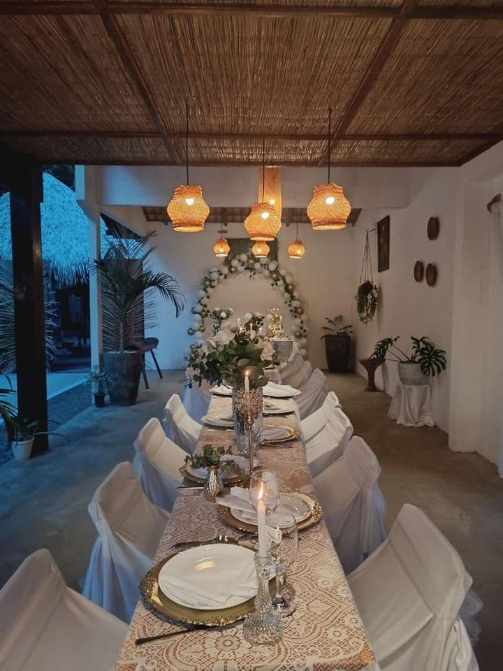 Mesa de evento posta ao anoitecer, iluminada por luminárias de fibra