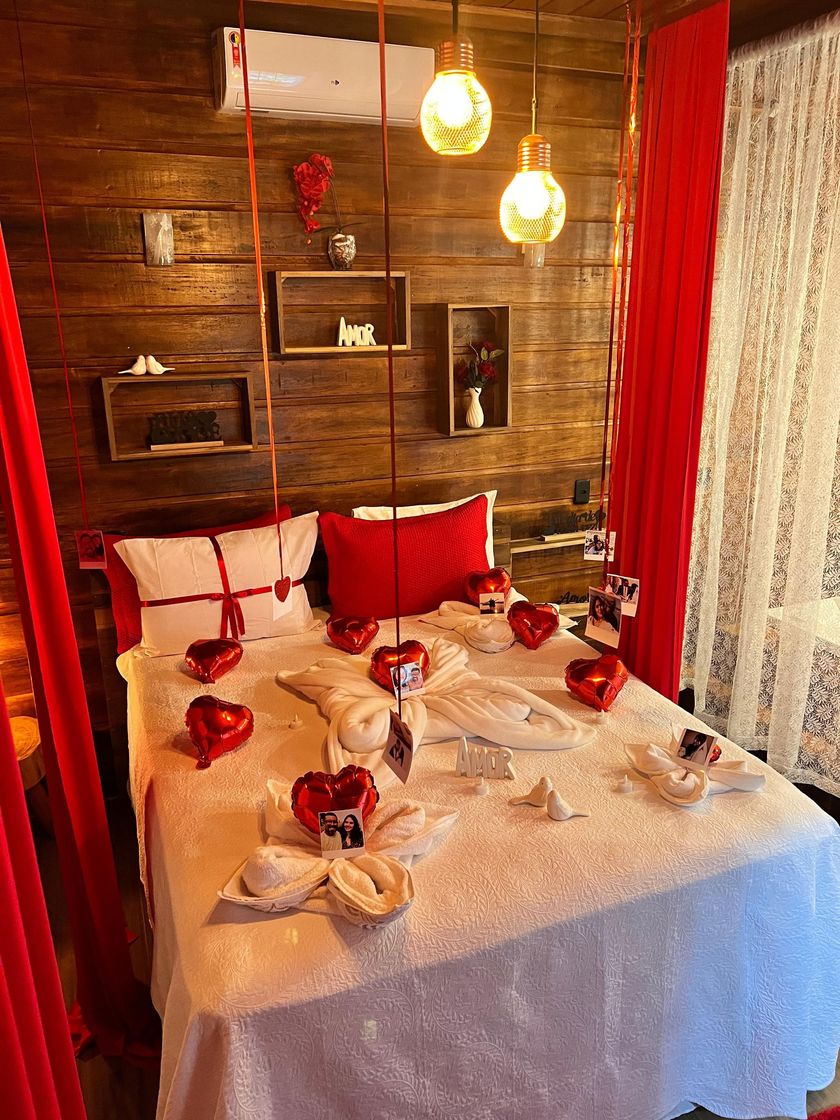 Decoração romântica com corações, toalhas dobradas e cortinas vermelhas